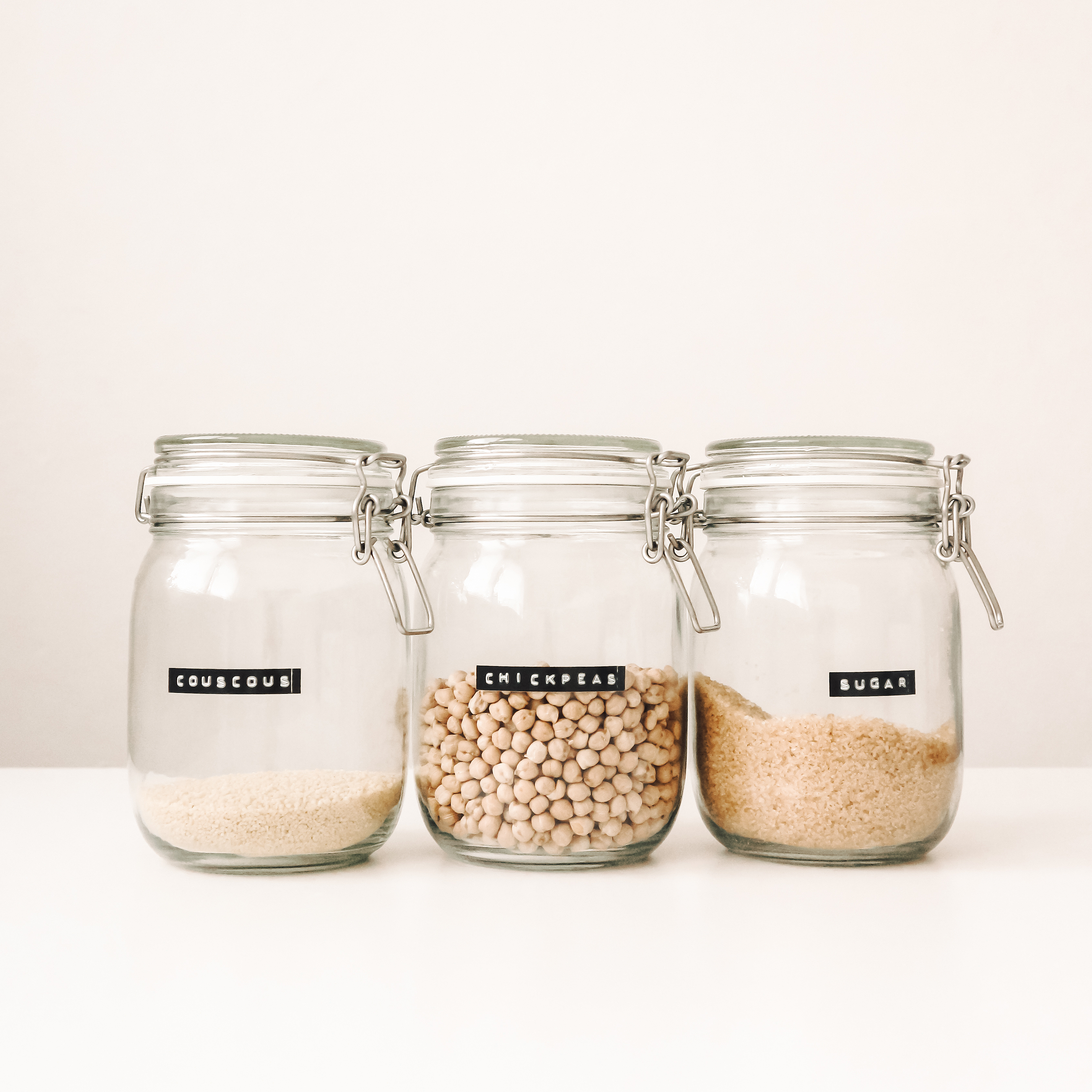 Glass food containers with couscous, chickpeas, and sugar.